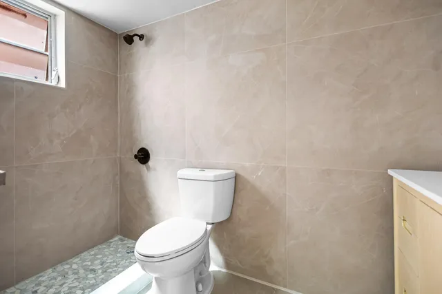a white toilet sitting next to a shower