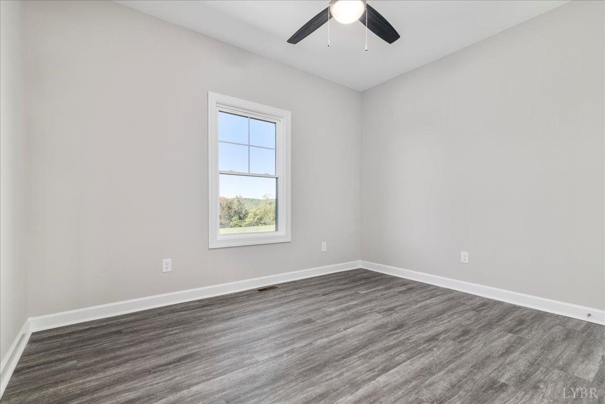 9830 Leesville Road Evington, VA 24550 - Photo 20 of 33 an empty room with wooden floor and windows