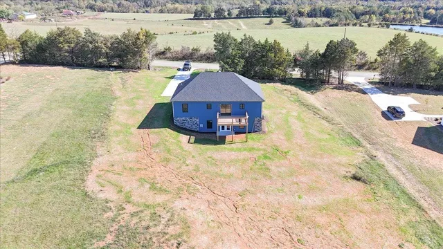 a view of a lake with a yard and large trees