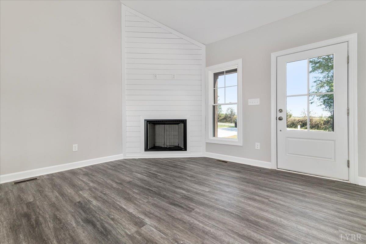 9830 Leesville Road Evington, VA 24550 - Photo 8 of 33 a view of an empty room with wooden floor and a window