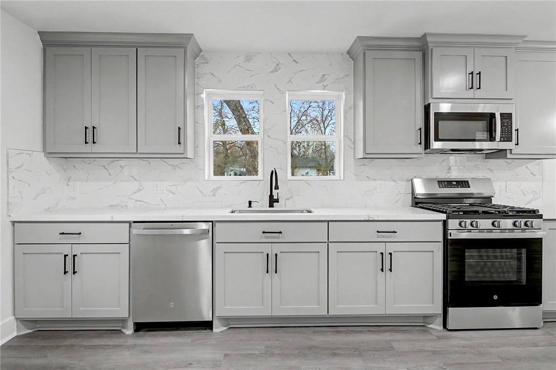902 Post Oak Street Hearne, TX 77859 - Photo 12 of 26 a kitchen with white cabinets stainless steel appliances and sink