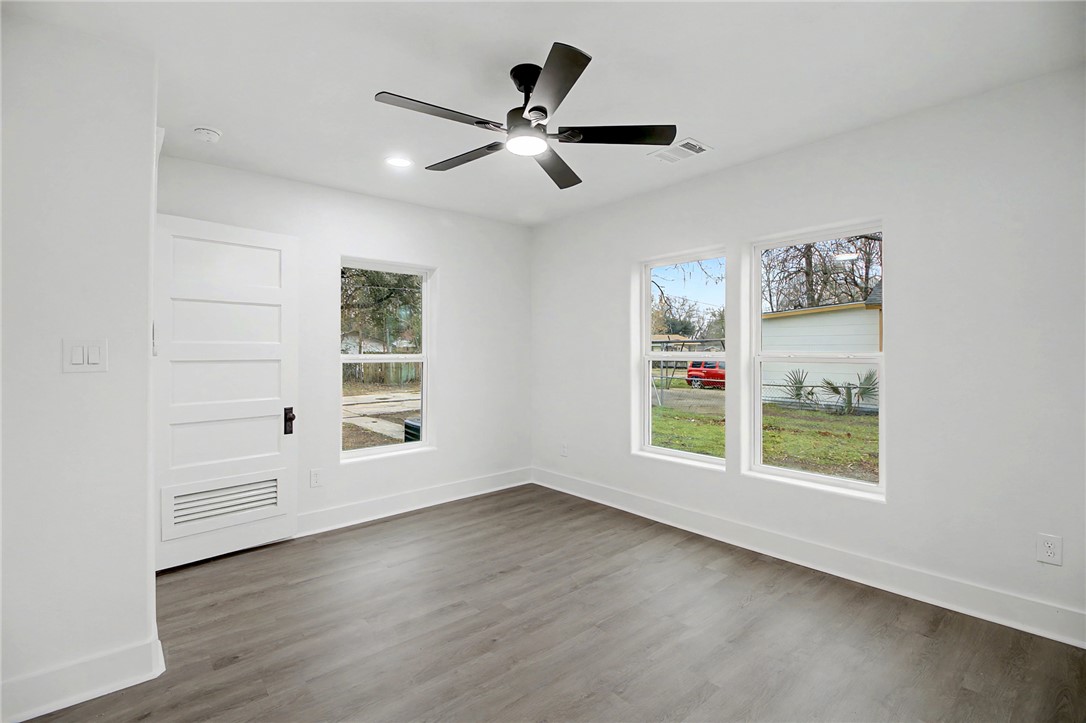 902 Post Oak Street Hearne, TX 77859 - Photo 17 of 26 wooden floor in an empty room with a window