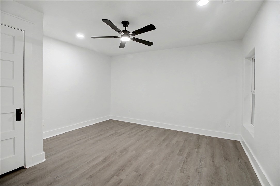 902 Post Oak Street Hearne, TX 77859 - Photo 19 of 26 an empty room with wooden floor and windows