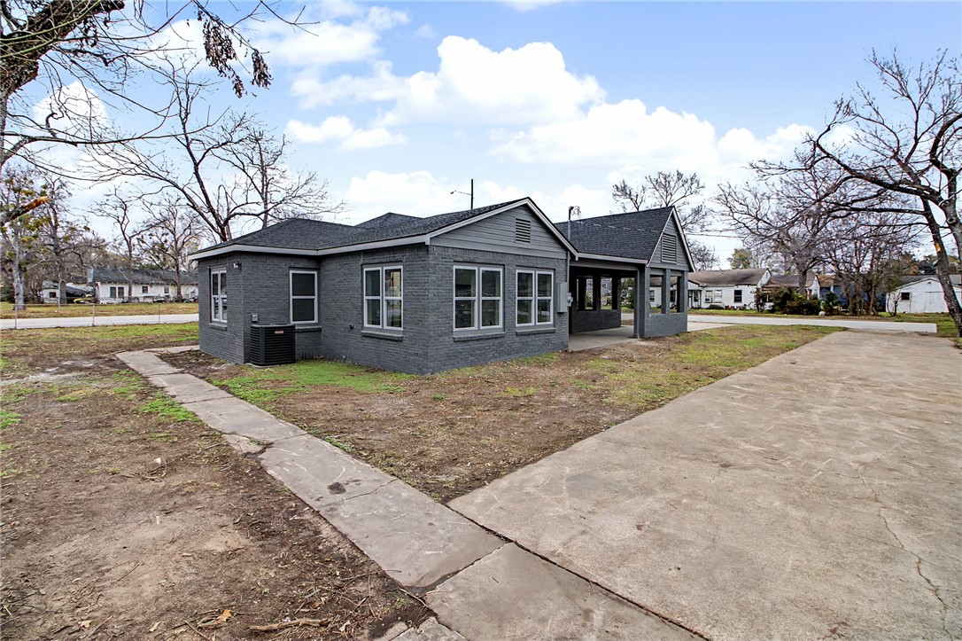 902 Post Oak Street Hearne, TX 77859 - Photo 5 of 26 a front view of a house with a garden and trees