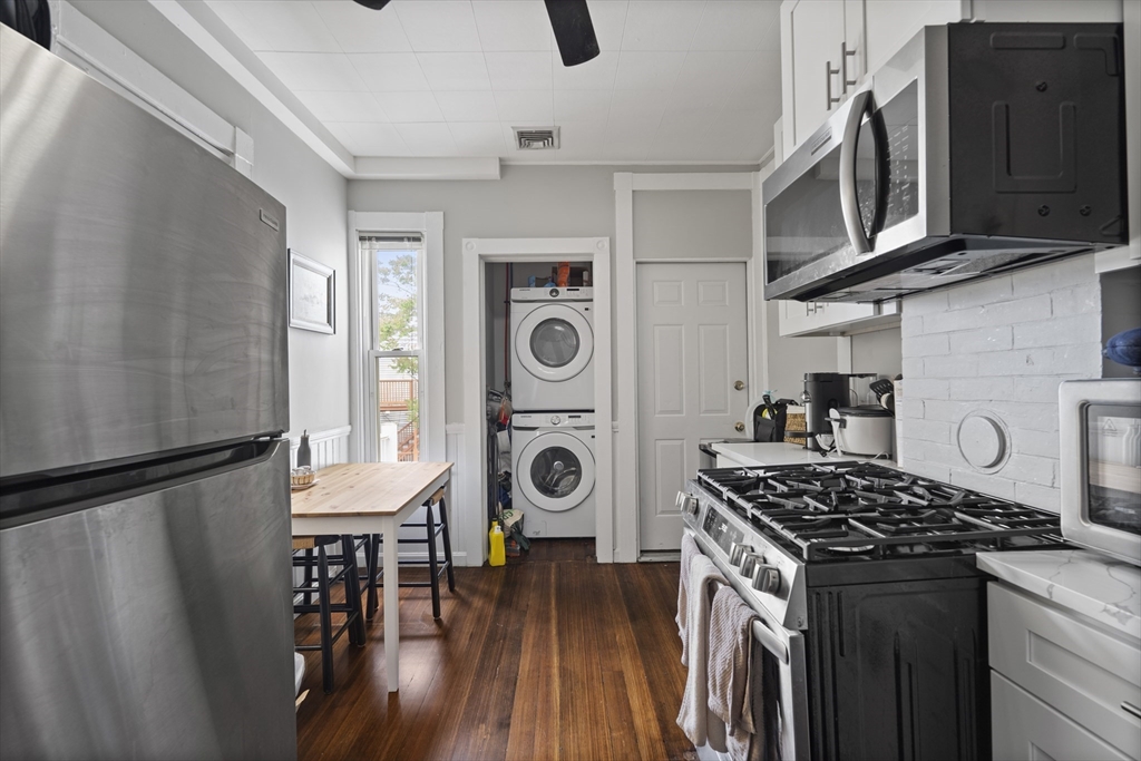194 Emerson Street Boston, MA 02127 - Photo 4 of 18 a kitchen with stainless steel appliances granite countertop a stove a sink dishwasher a refrigerator and wooden cabinets with wooden floor