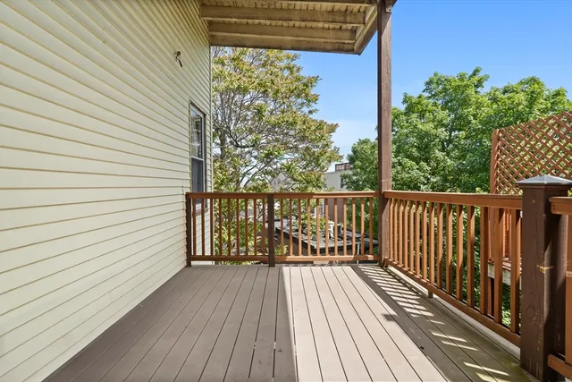 a view of balcony with wooden floor and fence and a floor to ceiling window