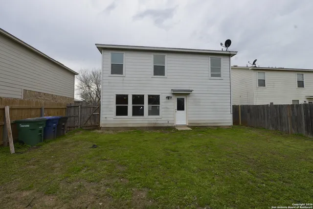 a backyard of a house with table and chairs