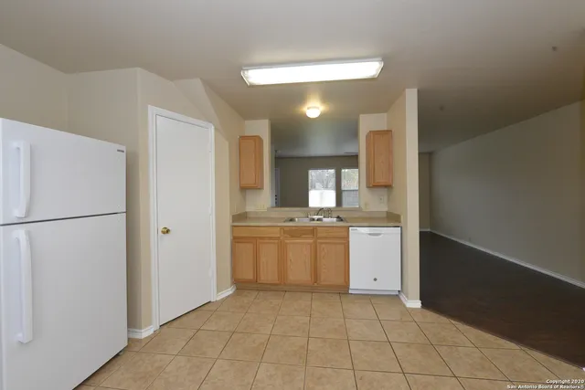 a kitchen with a refrigerator and white cabinets