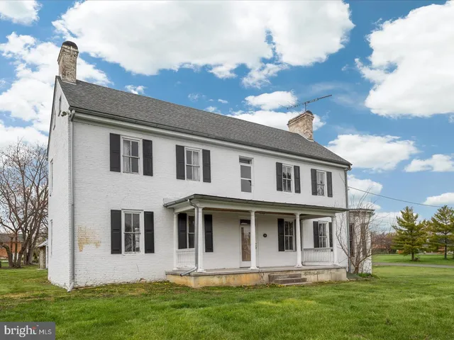 a view of a house with a big yard and large trees