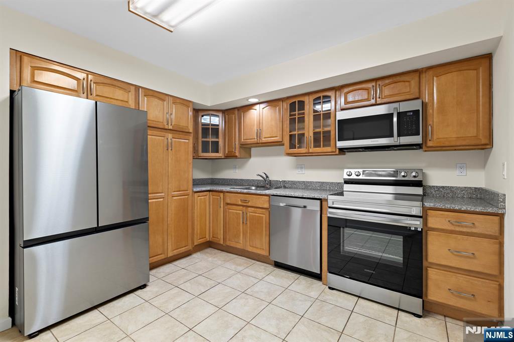319 Gorge Road, Unit 6 Cliffside Park, NJ 07010 - Photo 9 of 24 a kitchen with granite countertop a refrigerator stove and microwave