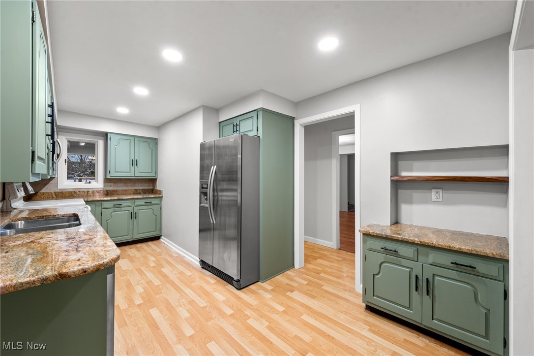 9513 Booth Road Willoughby, OH 44094 - Photo 22 of 45 Kitchen with stainless steel fridge, sink, light wood-type flooring, and green cabinetry