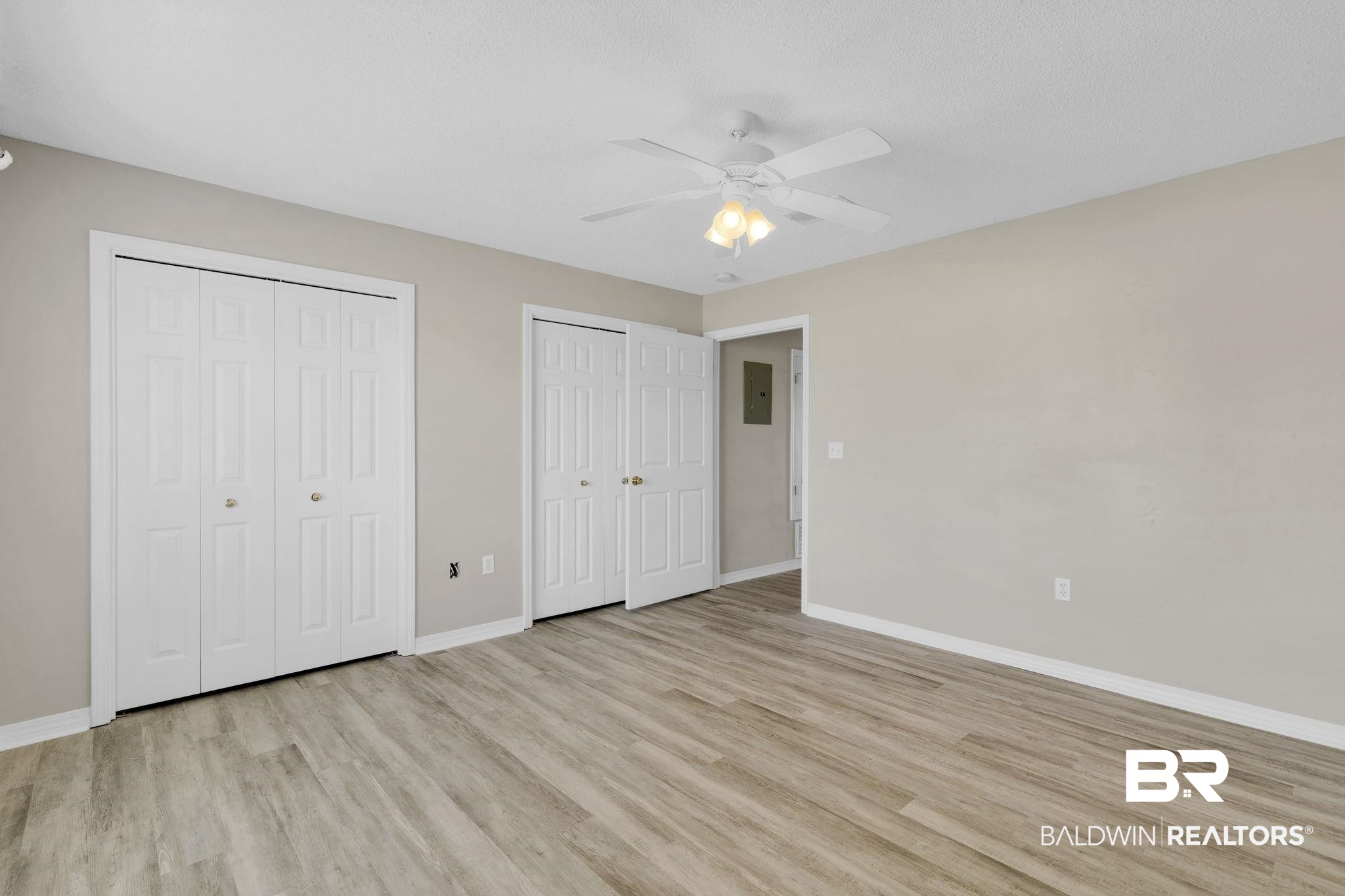 10238 Grove Drive Fairhope, AL 36532 - Photo 23 of 39 Unfurnished bedroom with ceiling fan, light wood-style flooring, and two closets