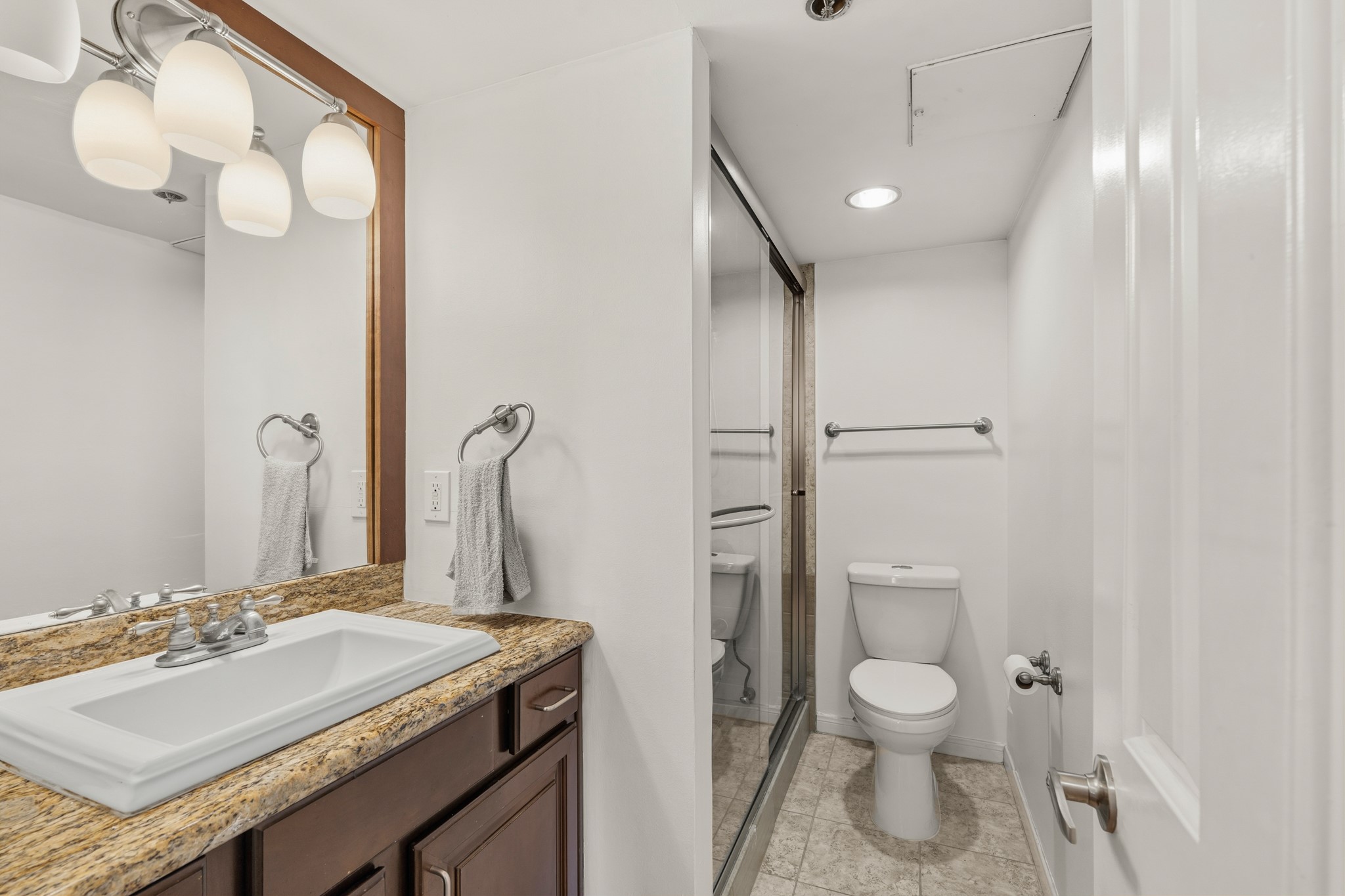 3525 Sage Road, Unit 1204 Houston, TX 77056 - Photo 11 of 25 Bathroom with vanity, mirror, and enclosed shower, designed for everyday functionality.