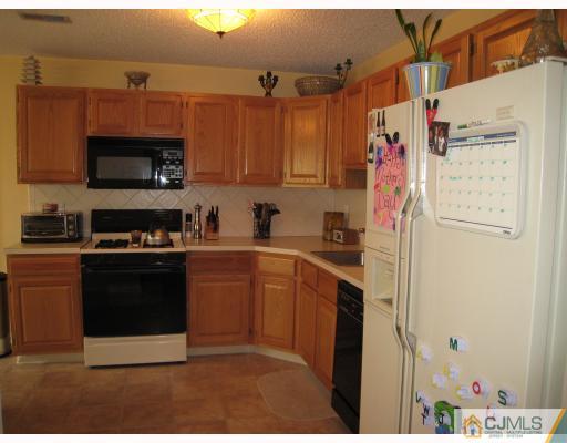 115 Inverness Drive Edison, NJ 08820 - Photo 3 of 10 a kitchen with stainless steel appliances white cabinets and a refrigerator