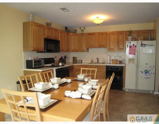 115 Inverness Drive Edison, NJ 08820 - Photo 5 of 10 a kitchen with a dining table and chairs