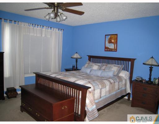 115 Inverness Drive Edison, NJ 08820 - Photo 6 of 10 a bedroom with a bed and a table in it