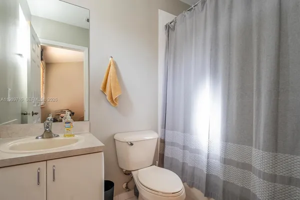 a bathroom with a sink vanity mirror and toilet