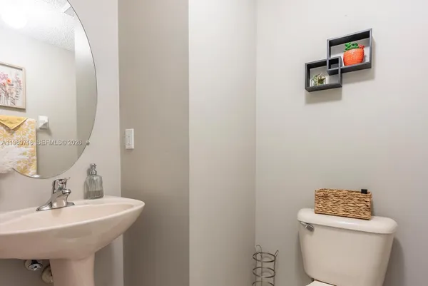 a bathroom with a sink a toilet and a mirror