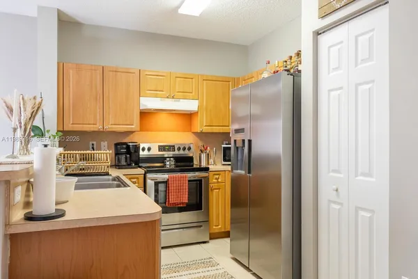 a kitchen with granite countertop a refrigerator stove and washer