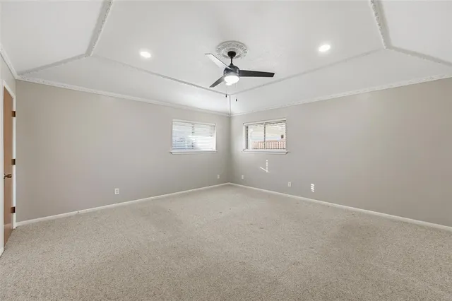 en empty room with windows and ceiling fan
