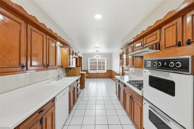 a kitchen with stainless steel appliances a stove a sink and a refrigerator