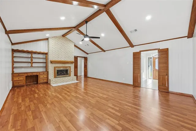 a view of empty room with wooden floor and fireplace
