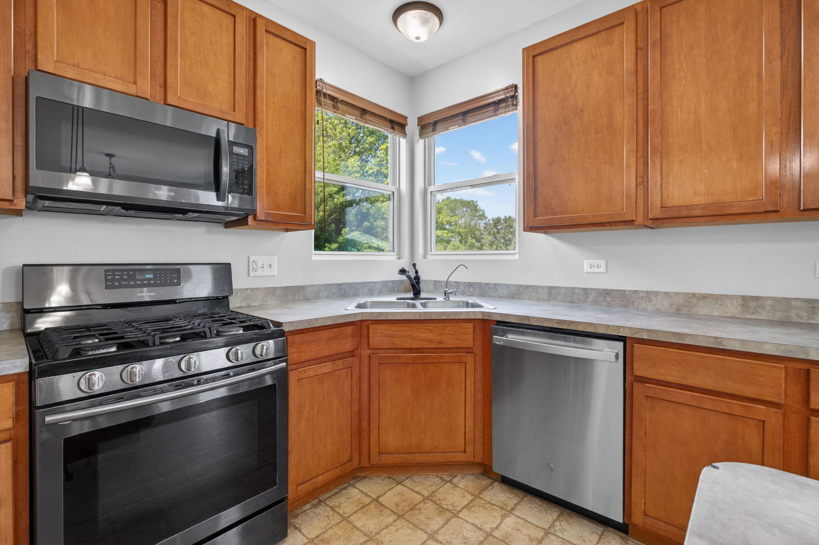 25204 Spring Street Manhattan, IL 60442 - Photo 9 of 34 a kitchen with stainless steel appliances granite countertop a sink stove and microwave