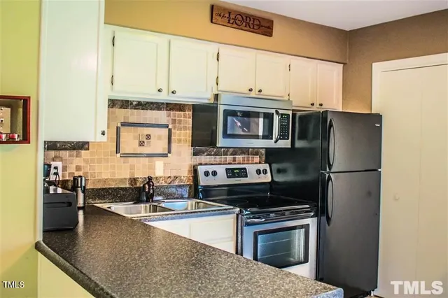 a kitchen with stainless steel appliances a stove a sink and a microwave