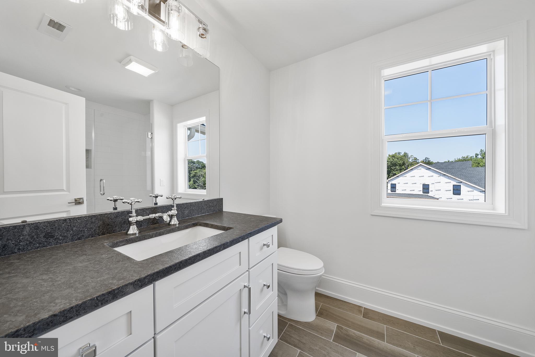 5 Big Oak Road Yardley, PA 19067 - Photo 22 of 27 a bathroom with a granite countertop sink a large mirror a toilet and a window