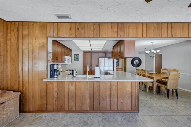 a kitchen with a sink a table and chairs