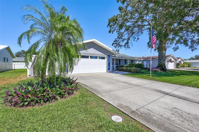 a front view of a house with a yard and potted plants