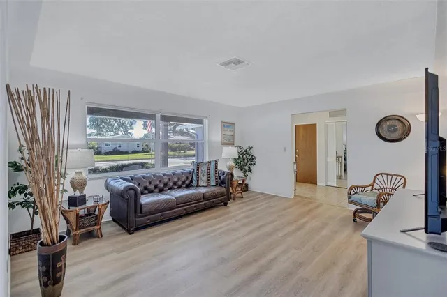 a living room with furniture hardwood floor and a large window
