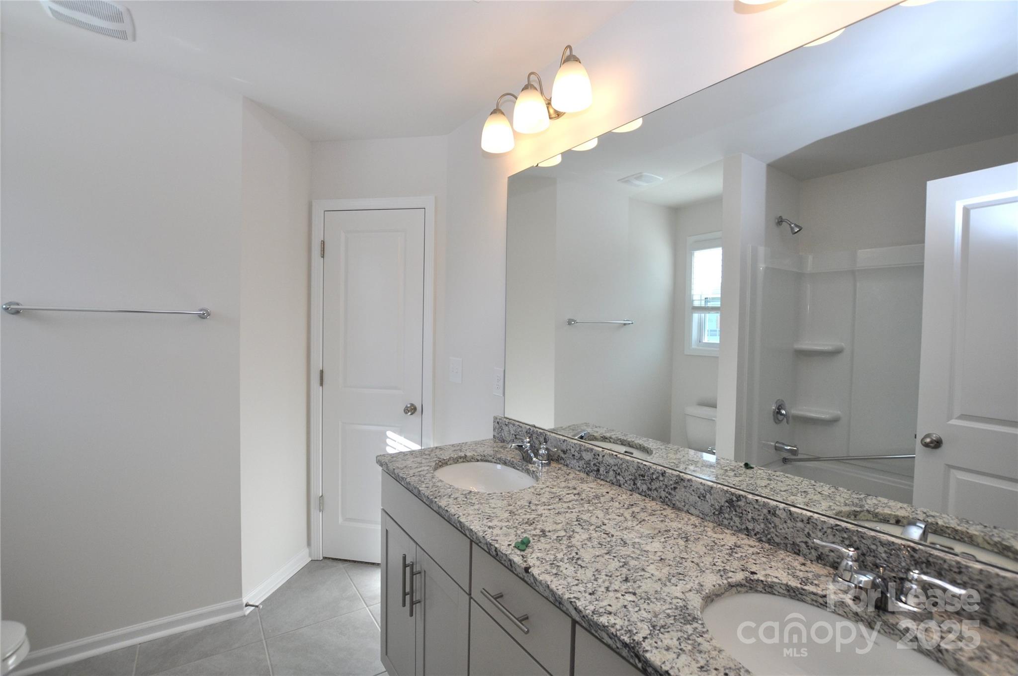 8007 Oakmere Road Waxhaw, NC 28173 - Photo 20 of 28 a bathroom with a granite countertop sink and a mirror