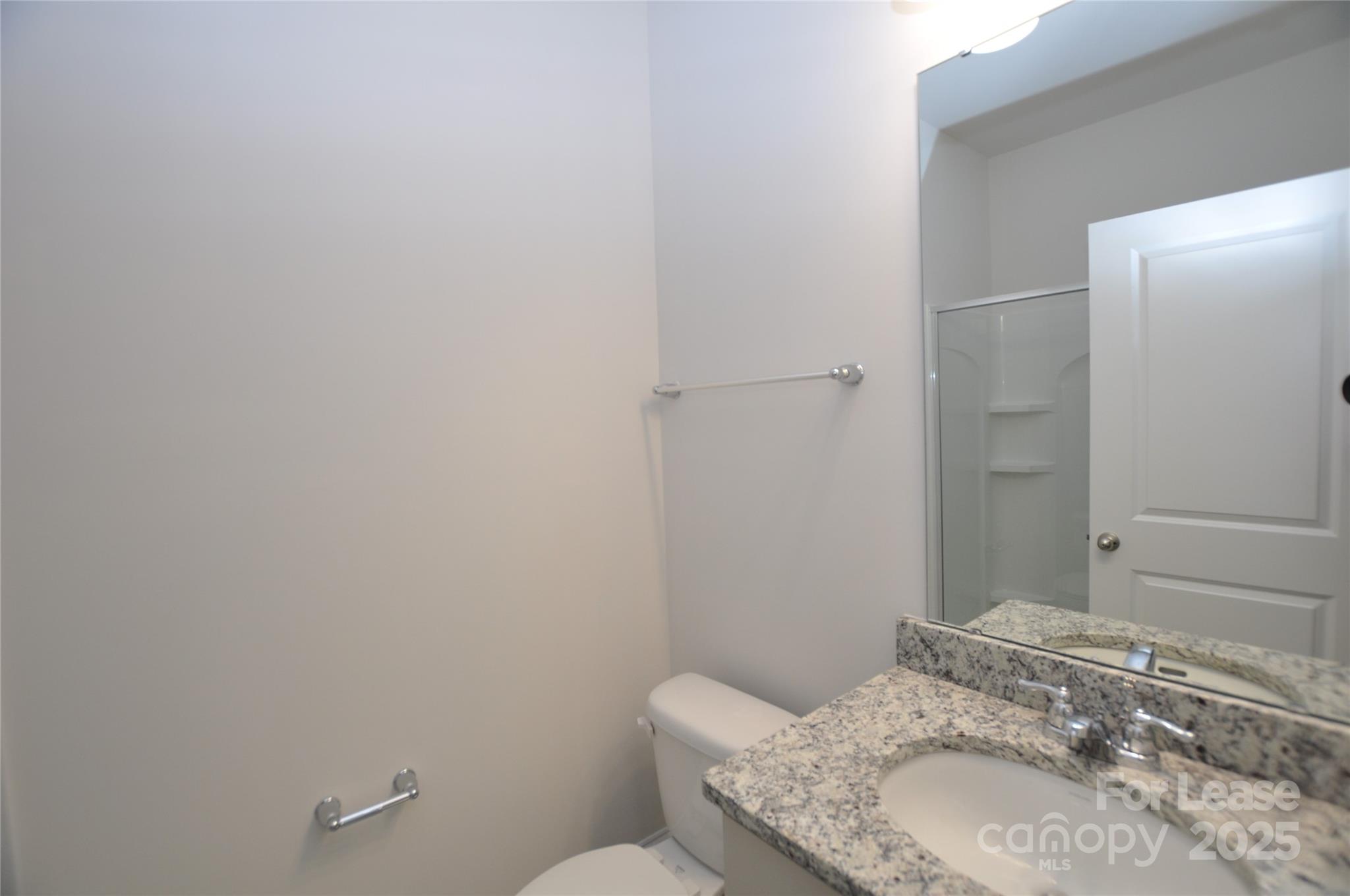8007 Oakmere Road Waxhaw, NC 28173 - Photo 10 of 28 a bathroom with a granite countertop sink and a mirror