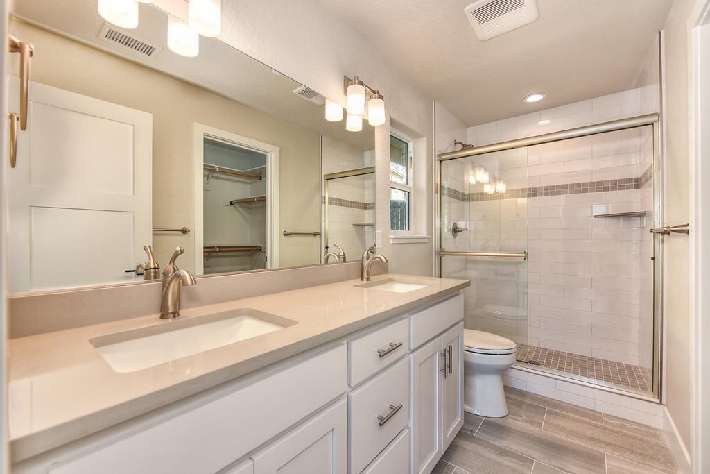 2667 Commons Place Auburn, CA 95603 - Photo 10 of 30 a bathroom with a granite countertop sink a toilet and a shower