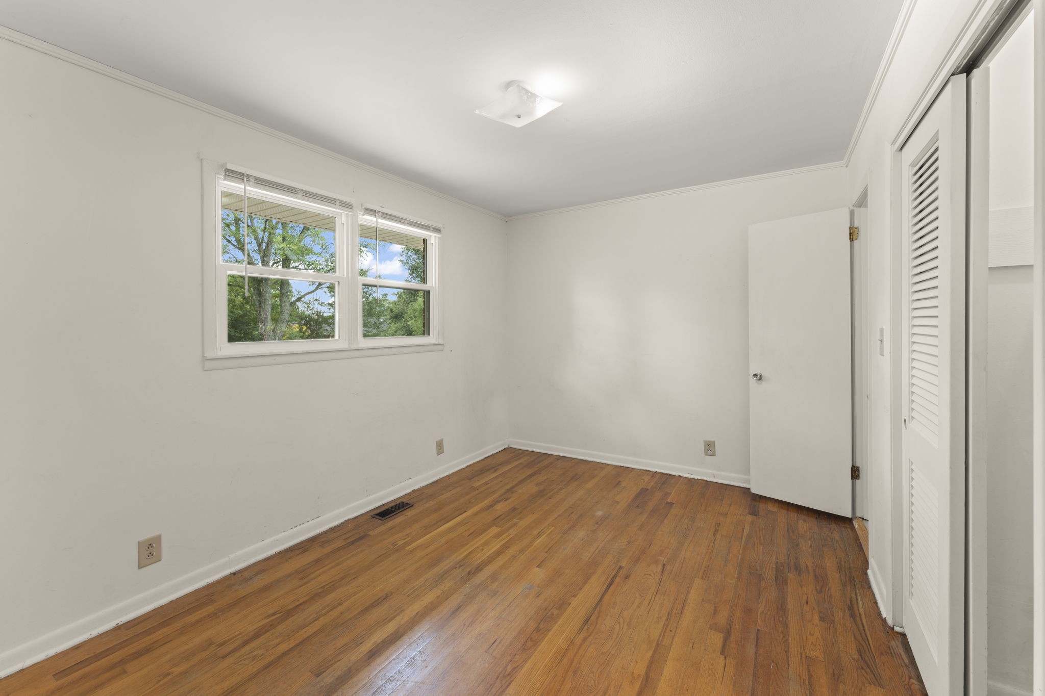 307 Mary Sharp Drive Decherd, TN 37324 - Photo 13 of 27 an empty room with wooden floor and windows
