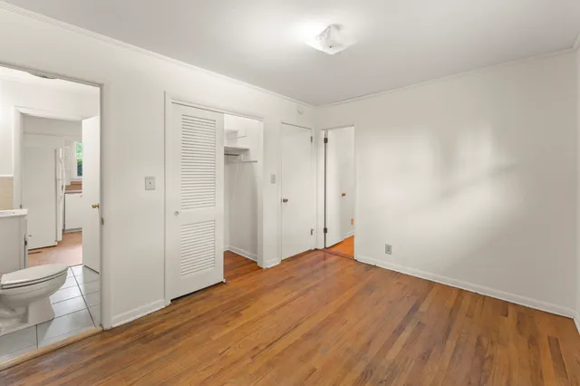 a big room with wooden floor and bathroom view