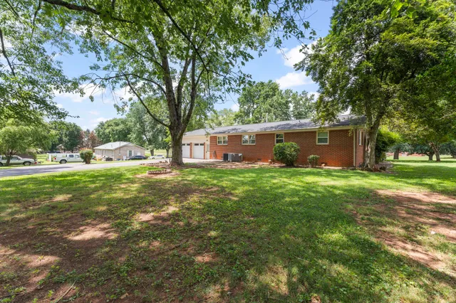 a view of a house with a yard and tree s