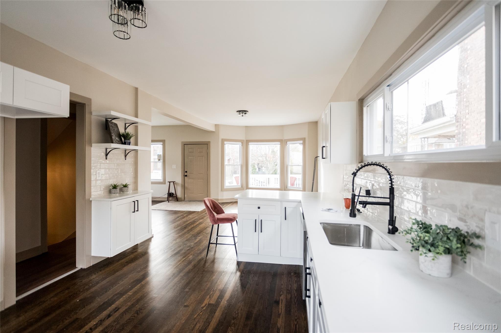 2630 Harding Street Detroit, MI 48214 - Photo 10 of 30 Open-concept kitchen with white shaker cabinetry, light-toned countertops, and a white subway tile backsplash