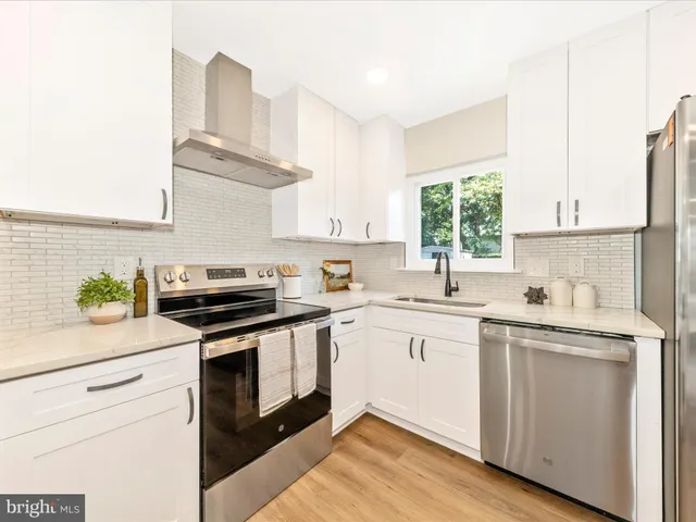 a kitchen with stainless steel appliances a sink a stove and window