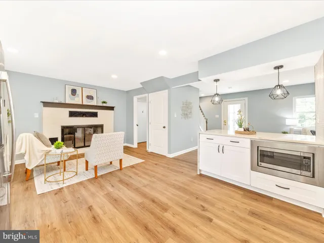 a large white kitchen with wooden floors and stainless steel appliances