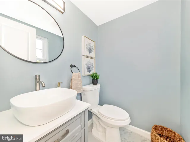 a bathroom with a sink a toilet and a mirror