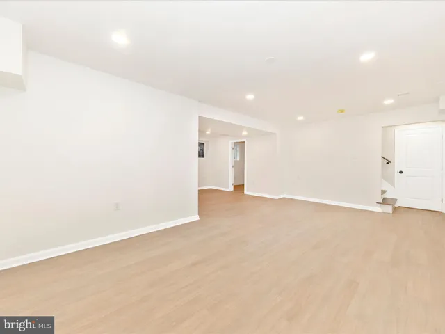 an empty room with a kitchen space and a window