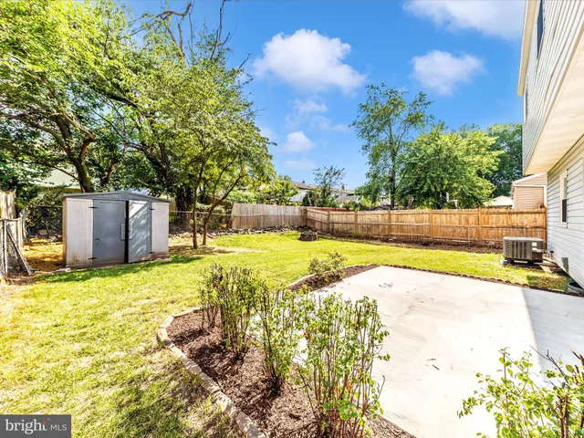 a view of yard with swimming pool and trees in the background