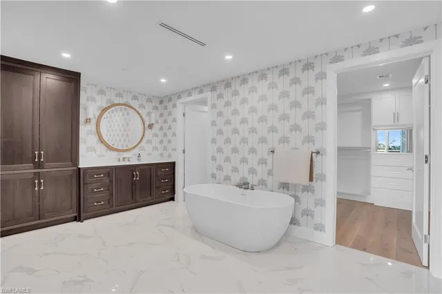 a spacious bathroom with a double vanity sink a mirror and a bathtub