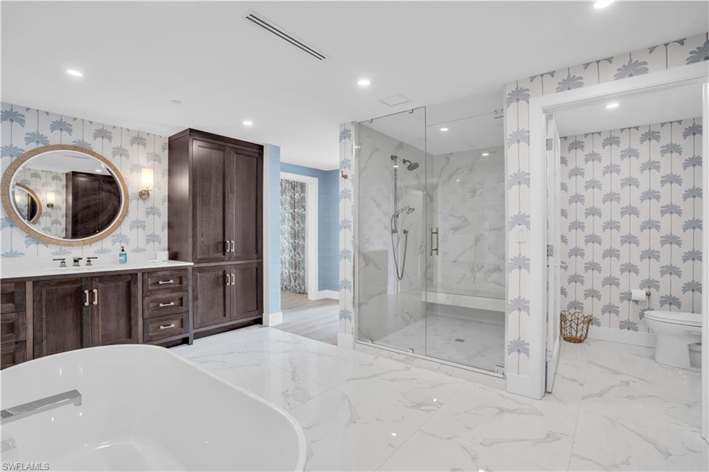 13945 Old Coast Road, Unit 301 Naples, FL 34110 - Photo 12 of 30 a spacious bathroom with a double vanity sink a large mirror and shower