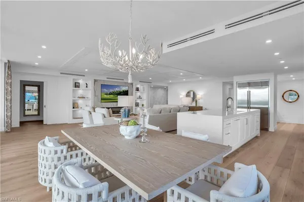 a kitchen with a dining table chairs and view of living room