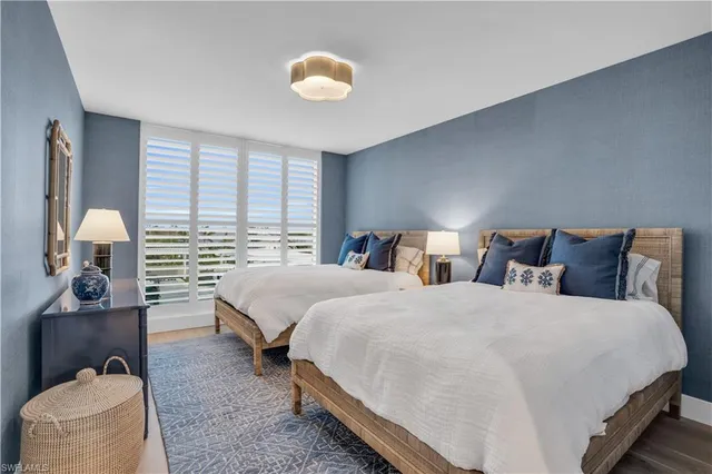 a bedroom with two beds and painting on the wall