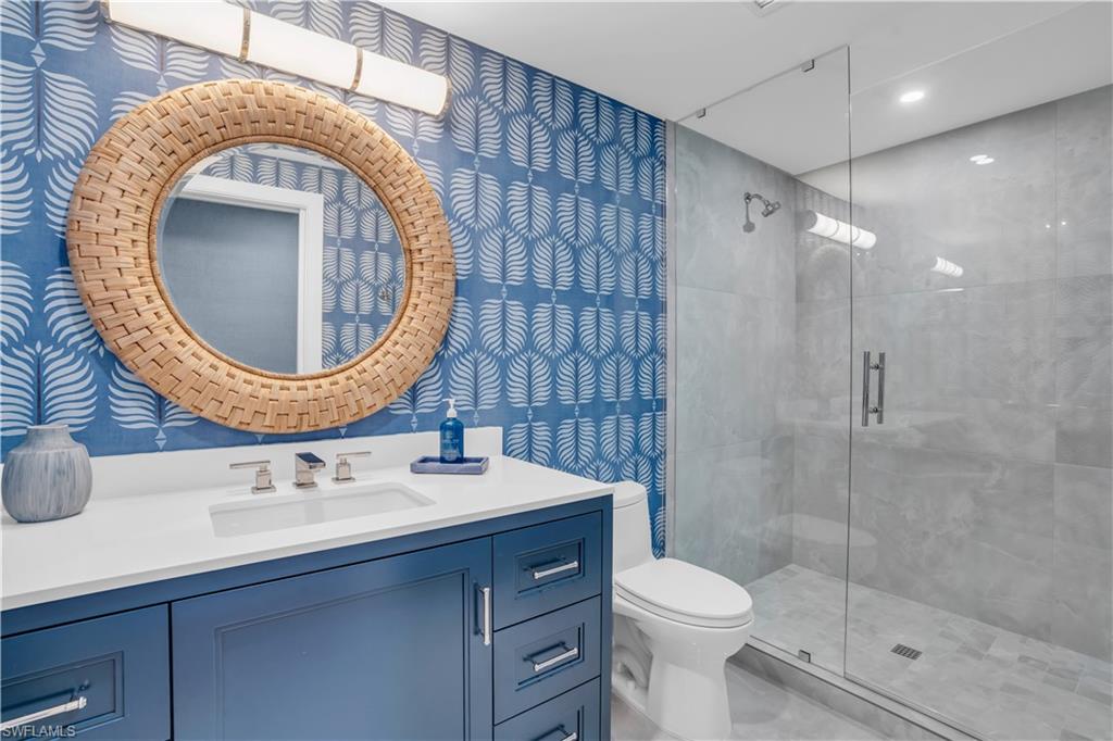 13945 Old Coast Road, Unit 301 Naples, FL 34110 - Photo 21 of 30 a bathroom with a sink mirror and toilet