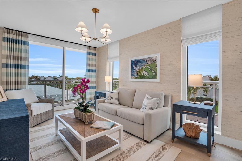 13945 Old Coast Road, Unit 301 Naples, FL 34110 - Photo 23 of 30 a living room with furniture a chandelier and a large window